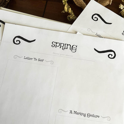 White paper with black text and decorative elements on a wooden surface